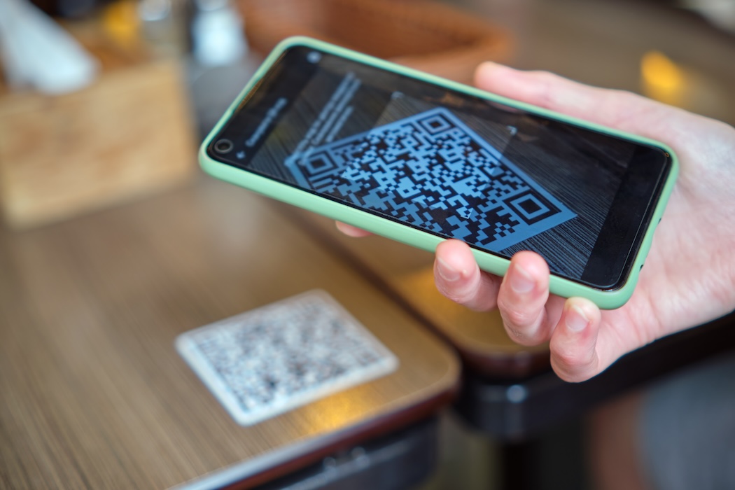 Comensal escaneando un código QR en la mesa para realizar un pedido